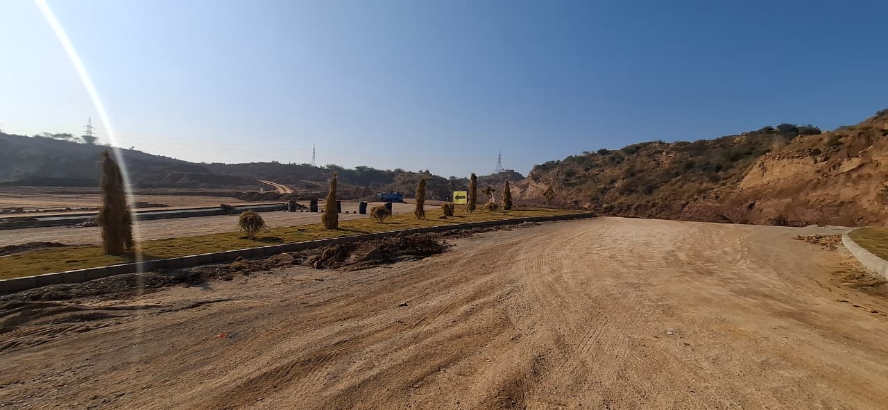 Roadwork beside a landscaped median and hillside in River View South